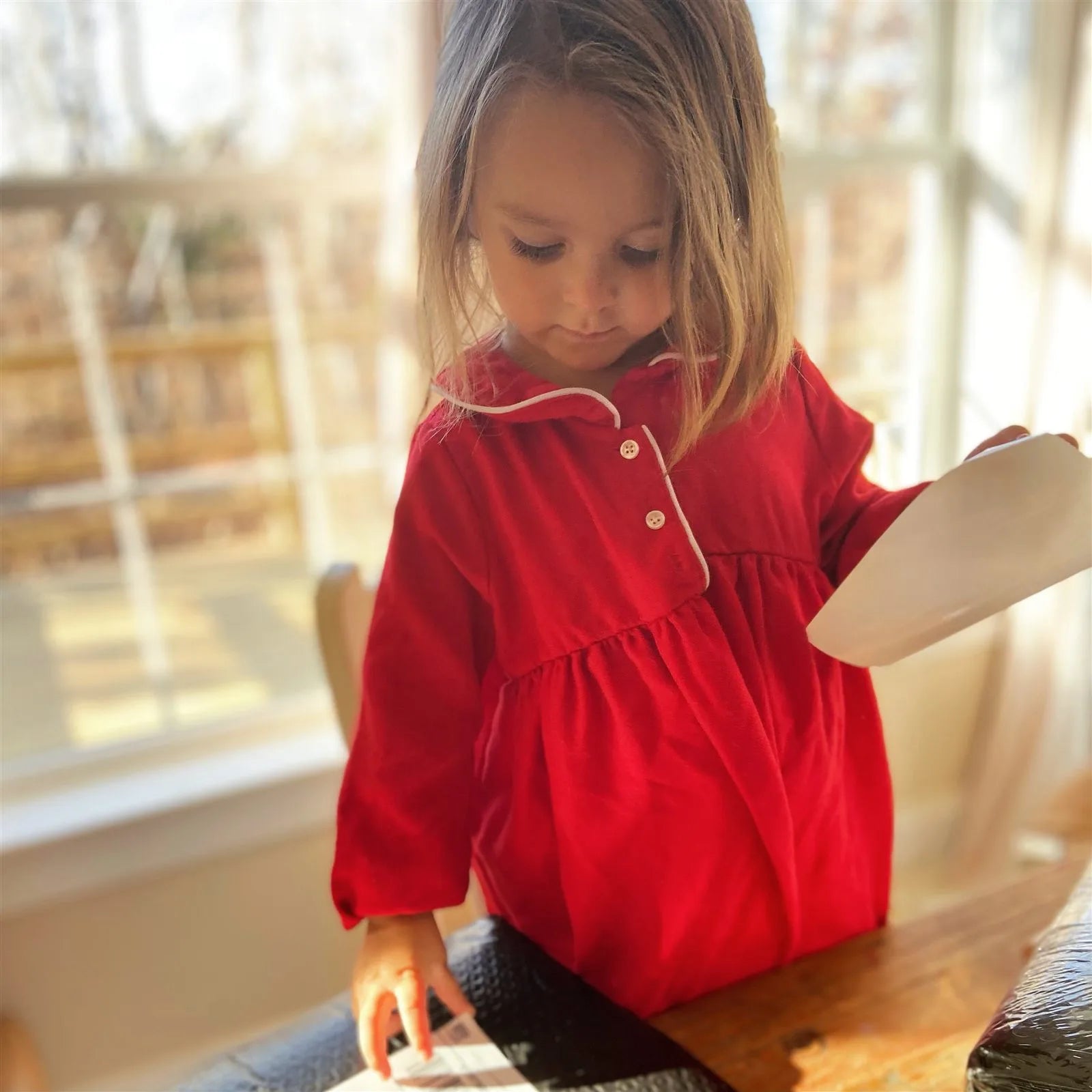 A child with a gift wrapped in The North Pole Sun