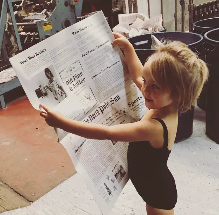 A child reading The North Pole Sun newspaper